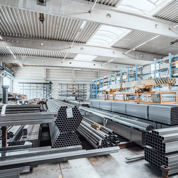 In einer Halle werden verschiedene Rohre gelagert.